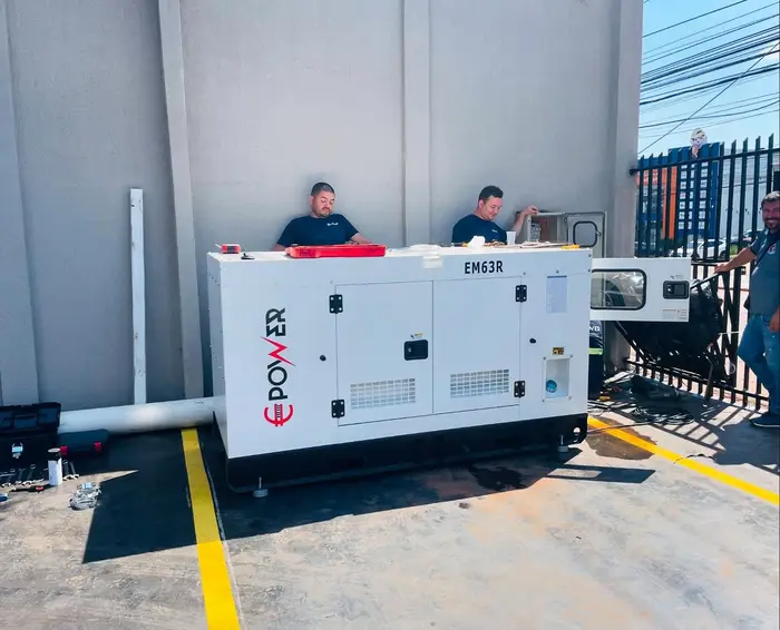 Dos técnicos de Emm Power trabajando sobre un generador de 63/69 kVA en JR Repuestos, km 4 de Ciudad del Este